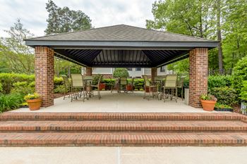 A gazebo with chairs and a table on a patio